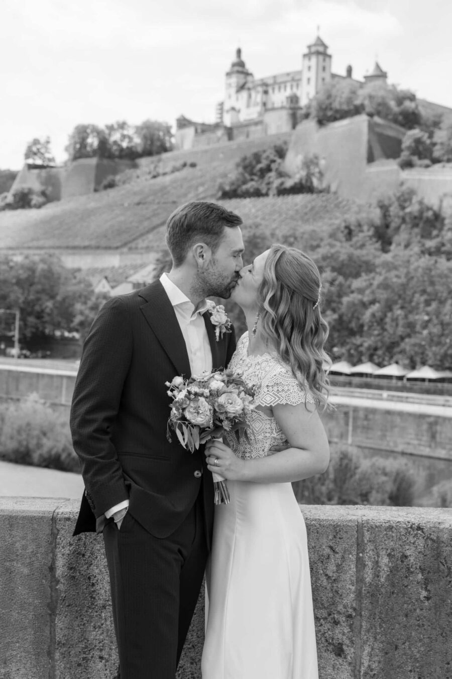 Hochzeit Steinburg Würzburg | Editorial Style & Party | Florian Knusper 107 Küssendes Brautpaar vor historischer Burg