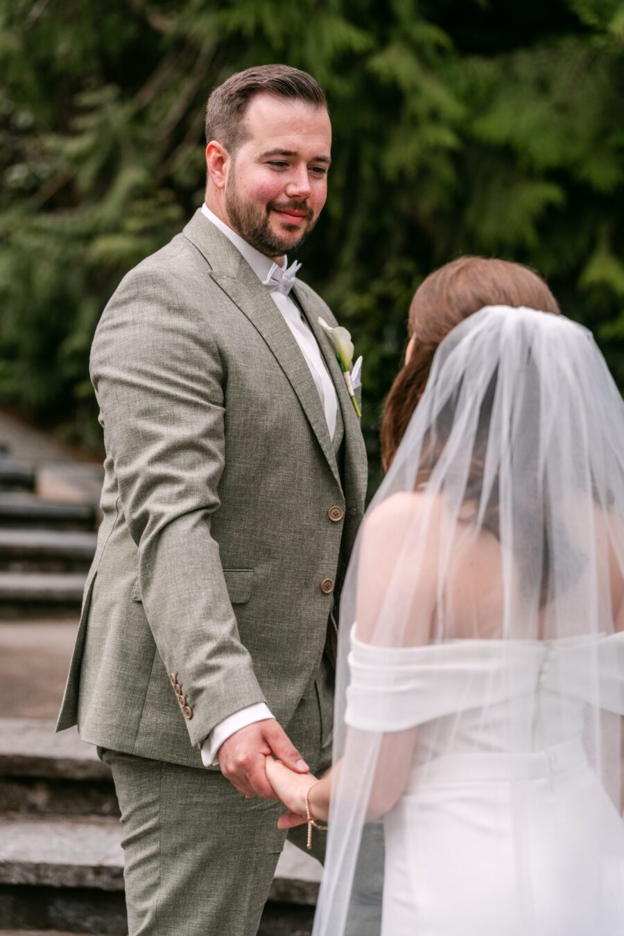 Hochzeit Insel Mainau Bodensee – Heiraten am Bodensee 145 Brautpaar hält sich an Steintreppen im Garten an den Händen