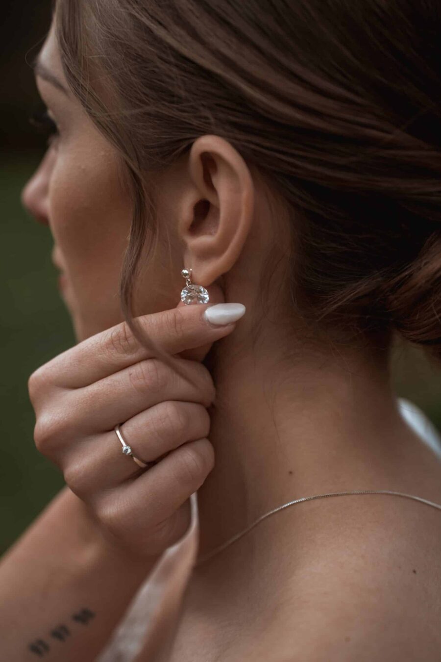 Nahaufnahme Braut mit Ohrschmuck und Verlobungsring