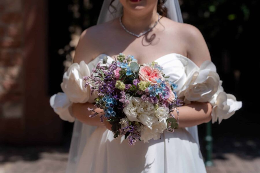 Braut mit Blumenstrauß in sommerlichem KleidHofgut Hünersdorff