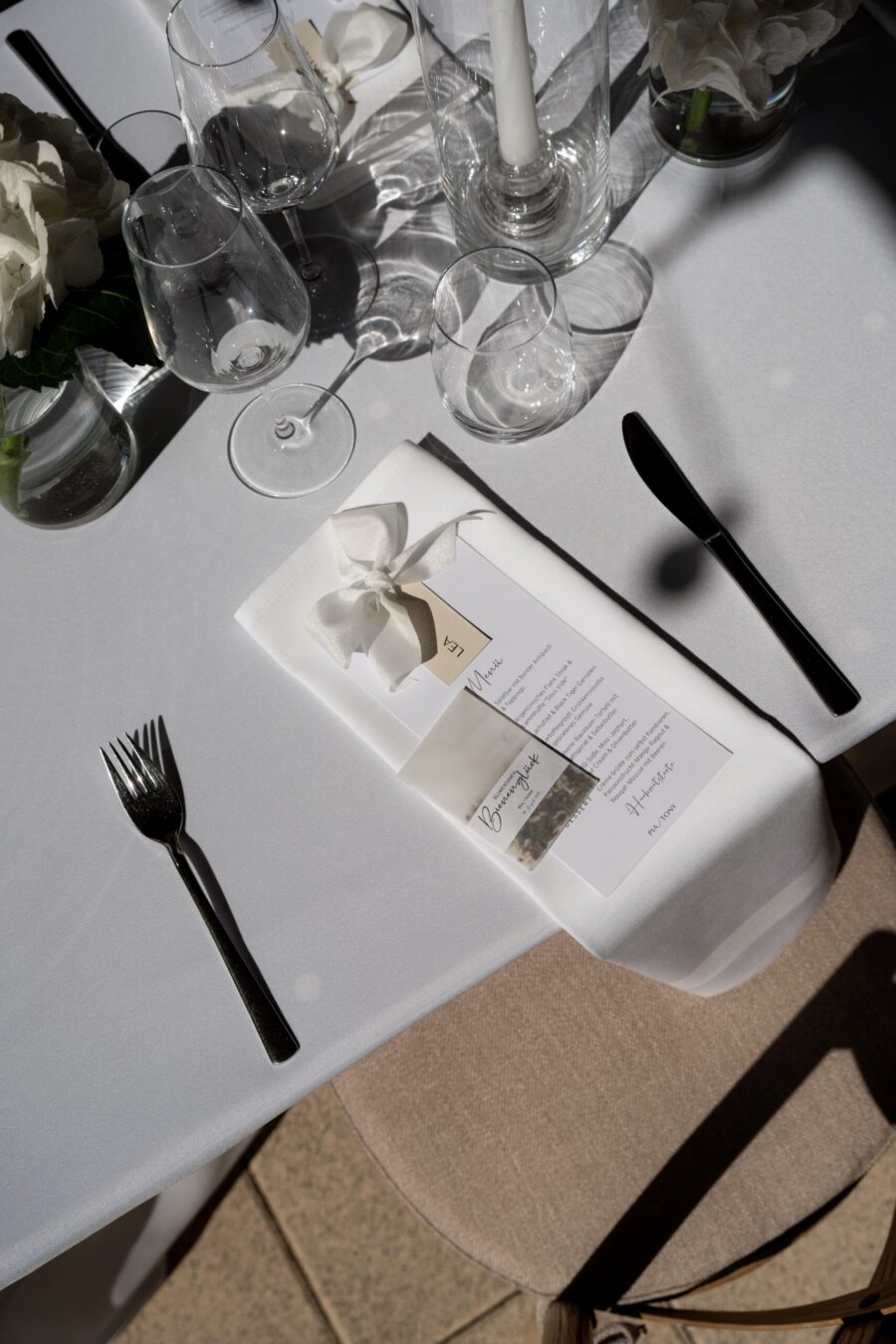 Elegant gedeckter Hochzeitstisch mit Menü und Deko.