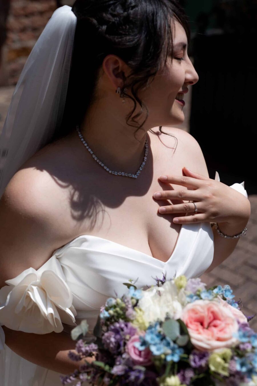 Braut mit Blumenstrauß im Sonnenschein. Hofgut Hünersdorff