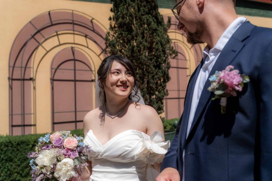 Brautpaar vor dekorativer Wand im Außenbereich. Hofgut Hünersdorff