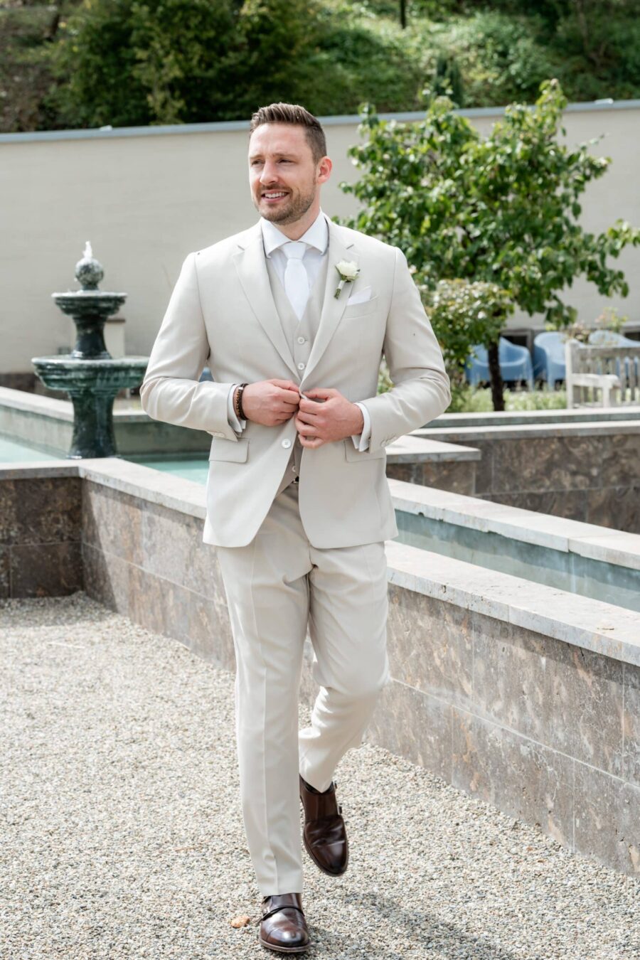 Bräutigam in hellem Anzug bei Gartenhochzeit