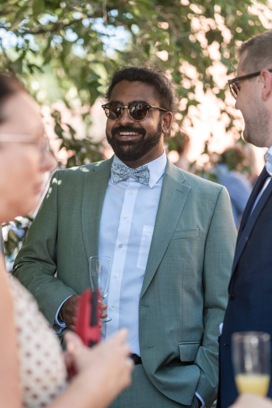 Gäste im Gespräch beim Sektempfang im Garten.