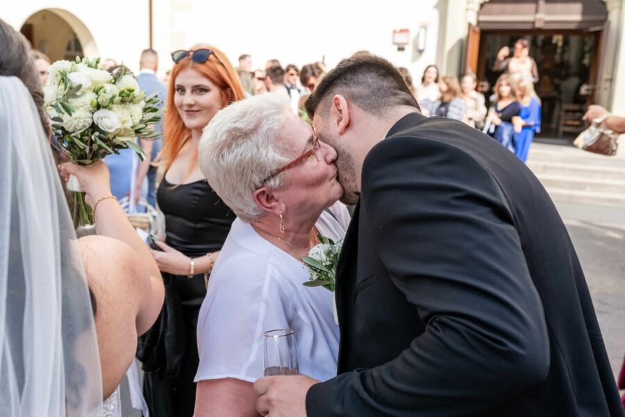 Gäste umarmen sich bei Hochzeitsempfang im Freien
