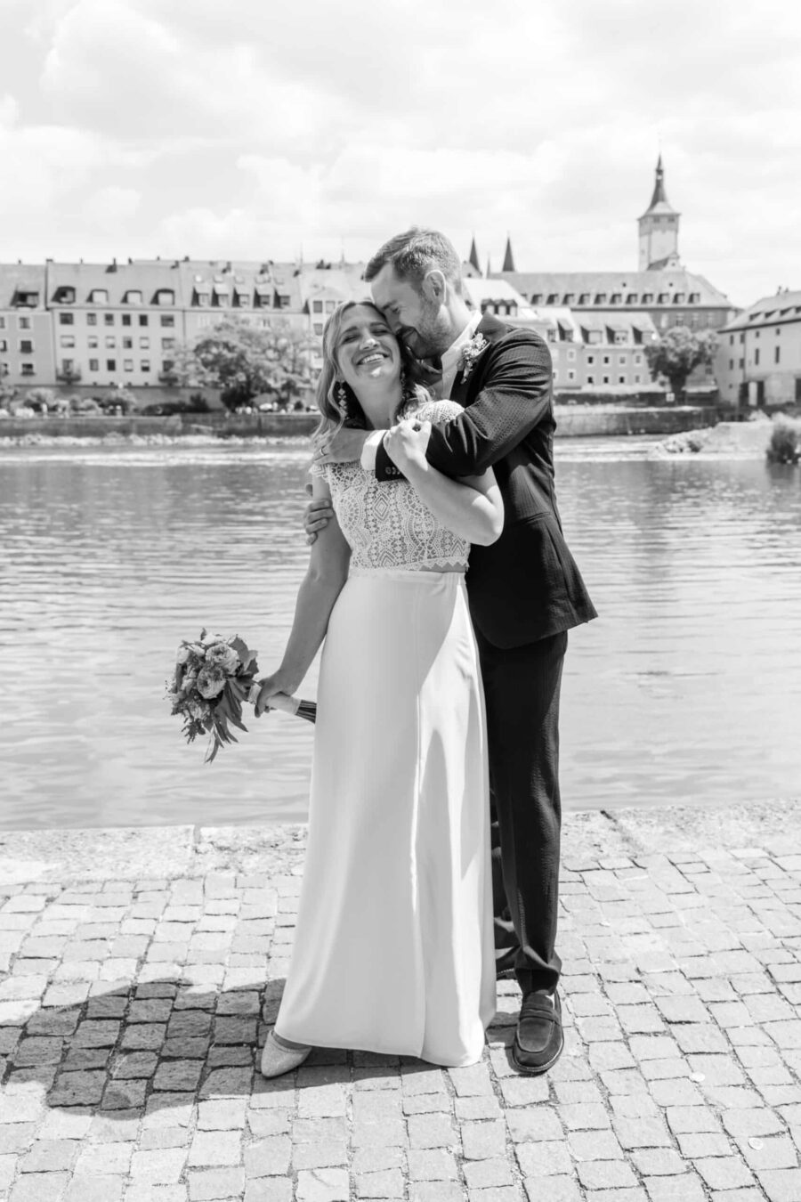 Hochzeit Steinburg Würzburg | Editorial Style & Party | Florian Knusper 112 Brautpaar umarmt sich am Flussufer