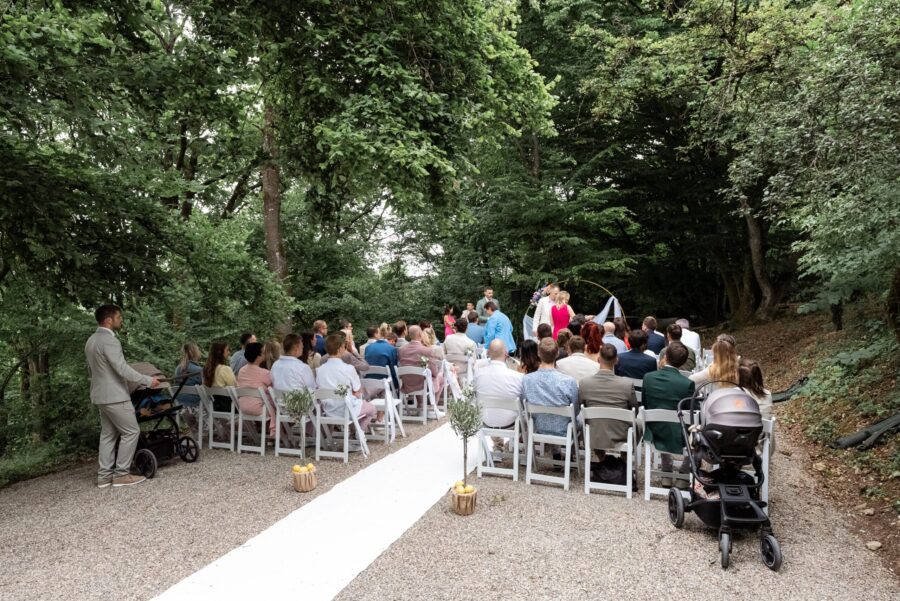 Gäste sitzen bei Waldtrauung im Sommer