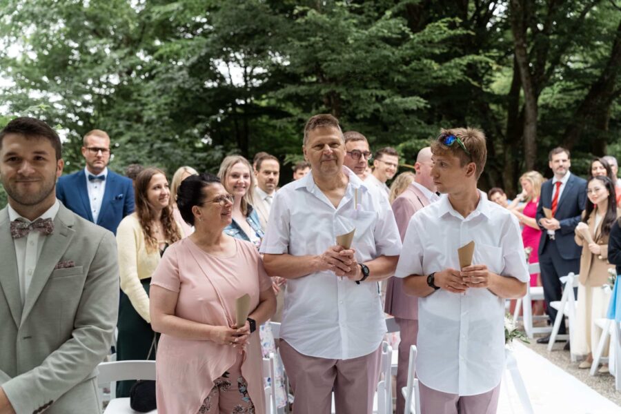 Hochzeitsgäste im Freien bei Zeremonie.