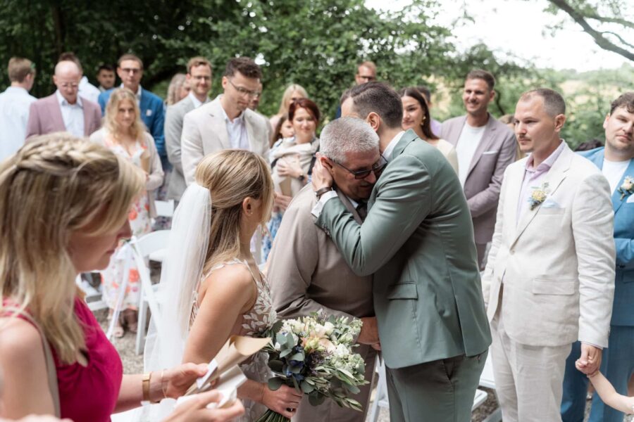 Hochzeitsfeier Umarmung im Garten mit Gästen