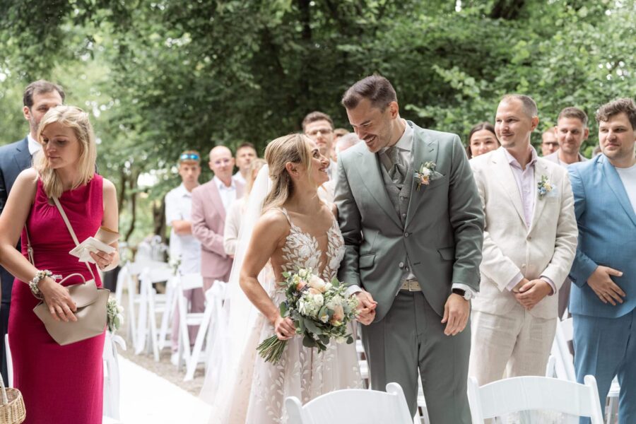 Brautpaar lächelnd bei der Trauung im Garten.