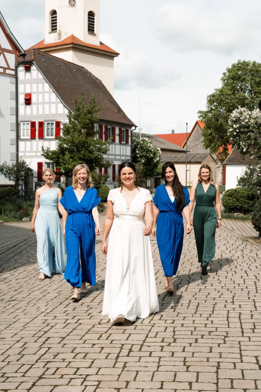 Braut und Freundinnen im Dorf vor Kirche