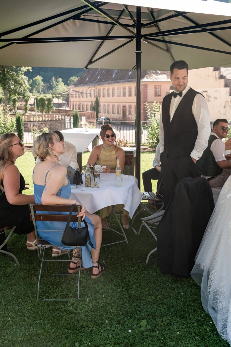 Gäste unter Pavillon bei Hochzeitsempfang im Freien