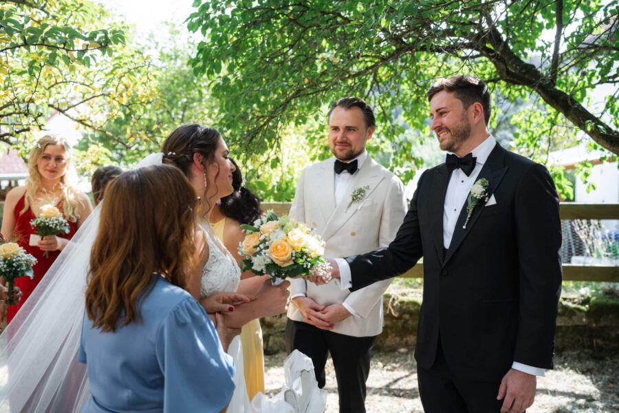 Hochzeit im Garten mit Brautstrauß und Gästen