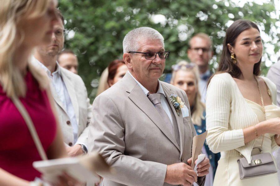 Gäste in eleganter Kleidung bei Hochzeit im Freien
