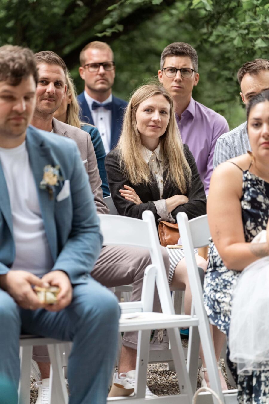 Gäste sitzen bei Zeremonie im Garten.