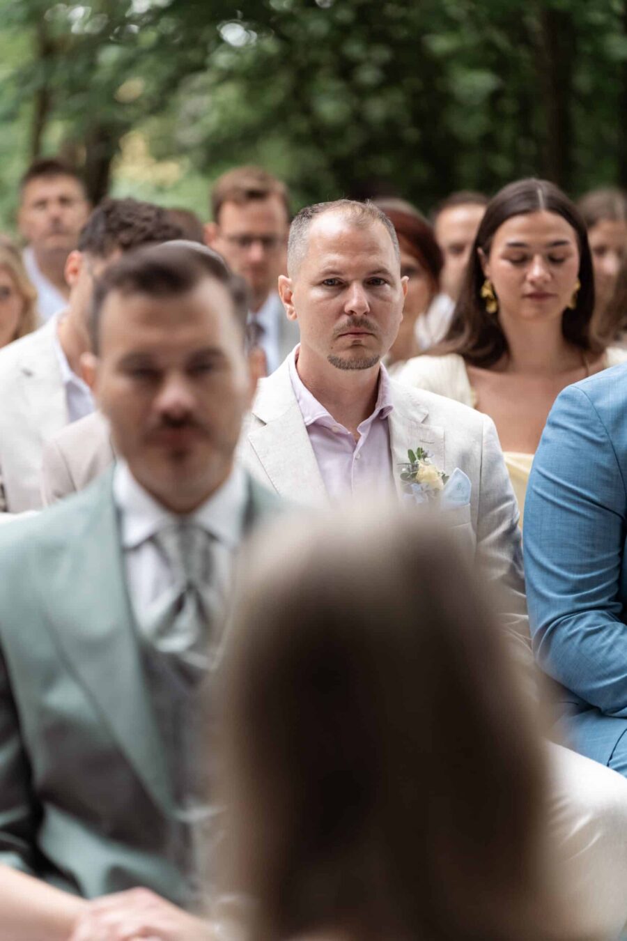 Gäste sitzen bei einer Waldhochzeit.