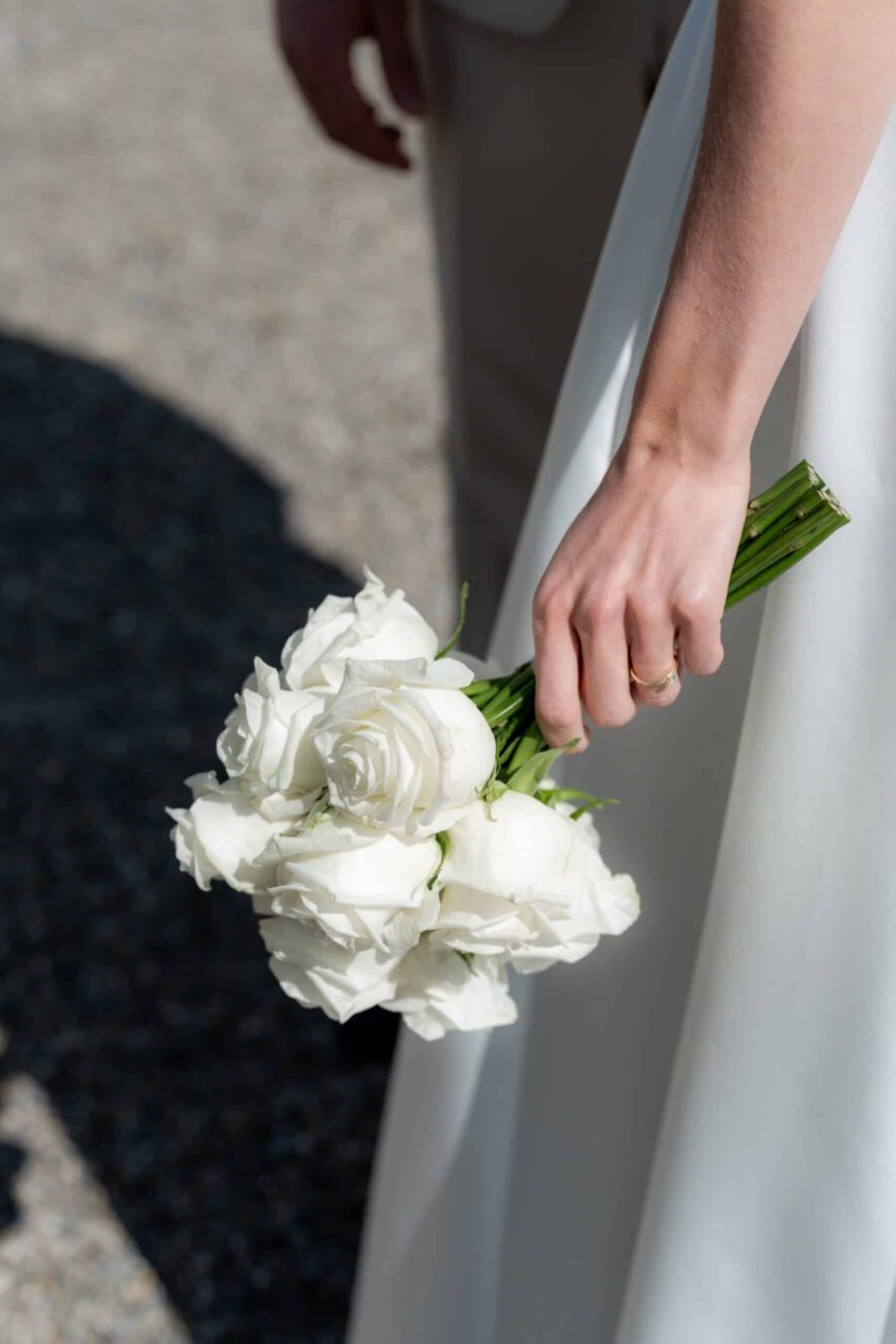 Braut hält weißen Rosenstrauß