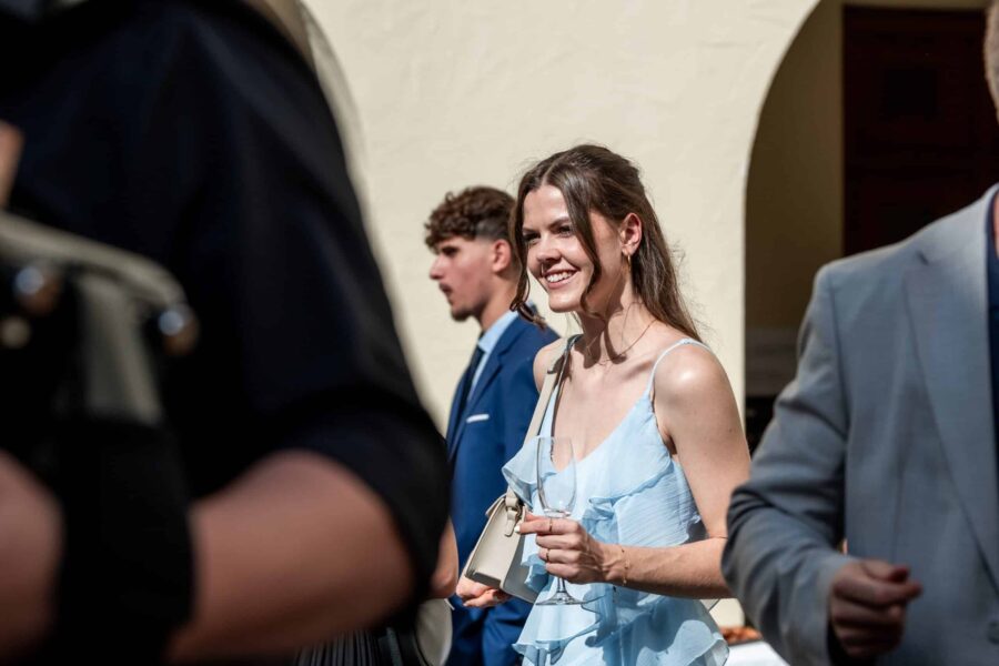 Gäste beim Empfang in eleganter Kleidung im Freien.