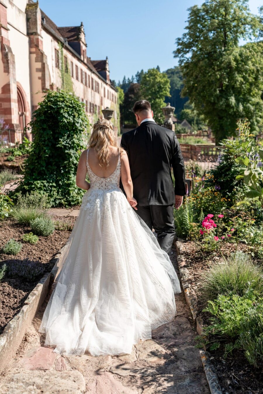 Brautpaar spaziert im Garten einer historischen Anlage