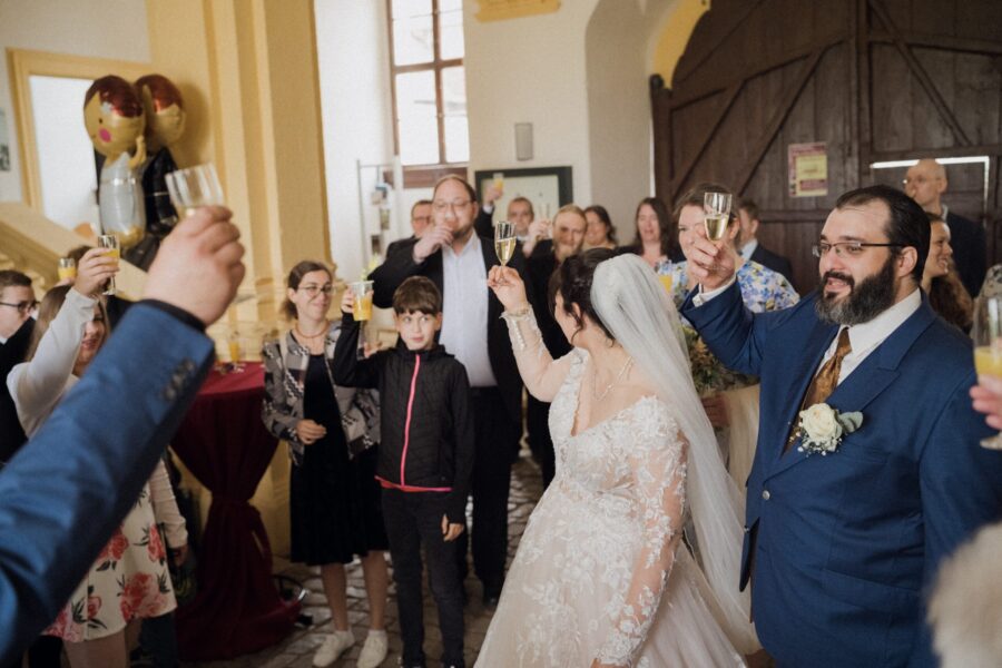 Hochzeitsfeier: Gäste stoßen mit Brautpaar an