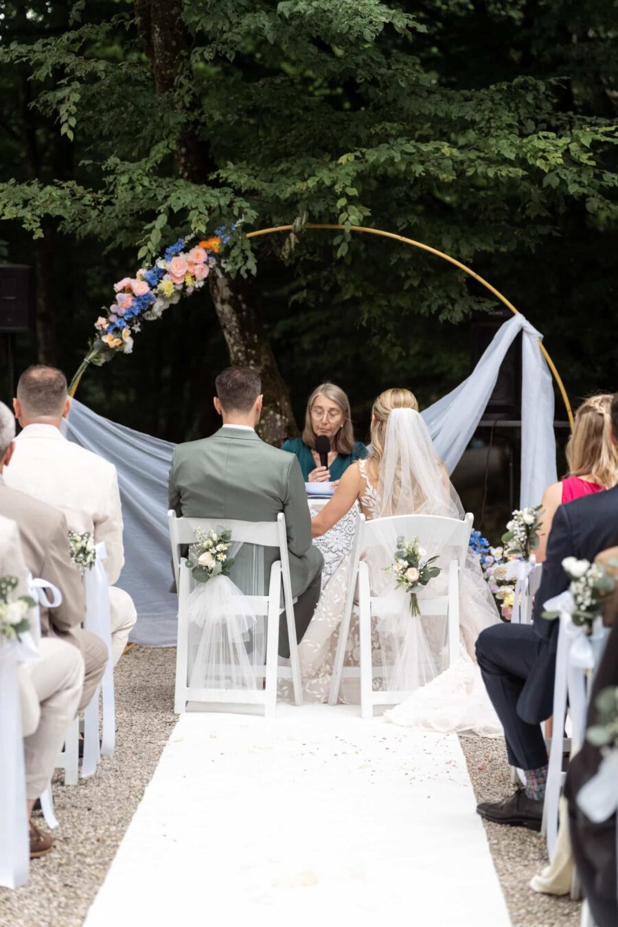 Trauung im Freien mit Gästen und Blumenbogen