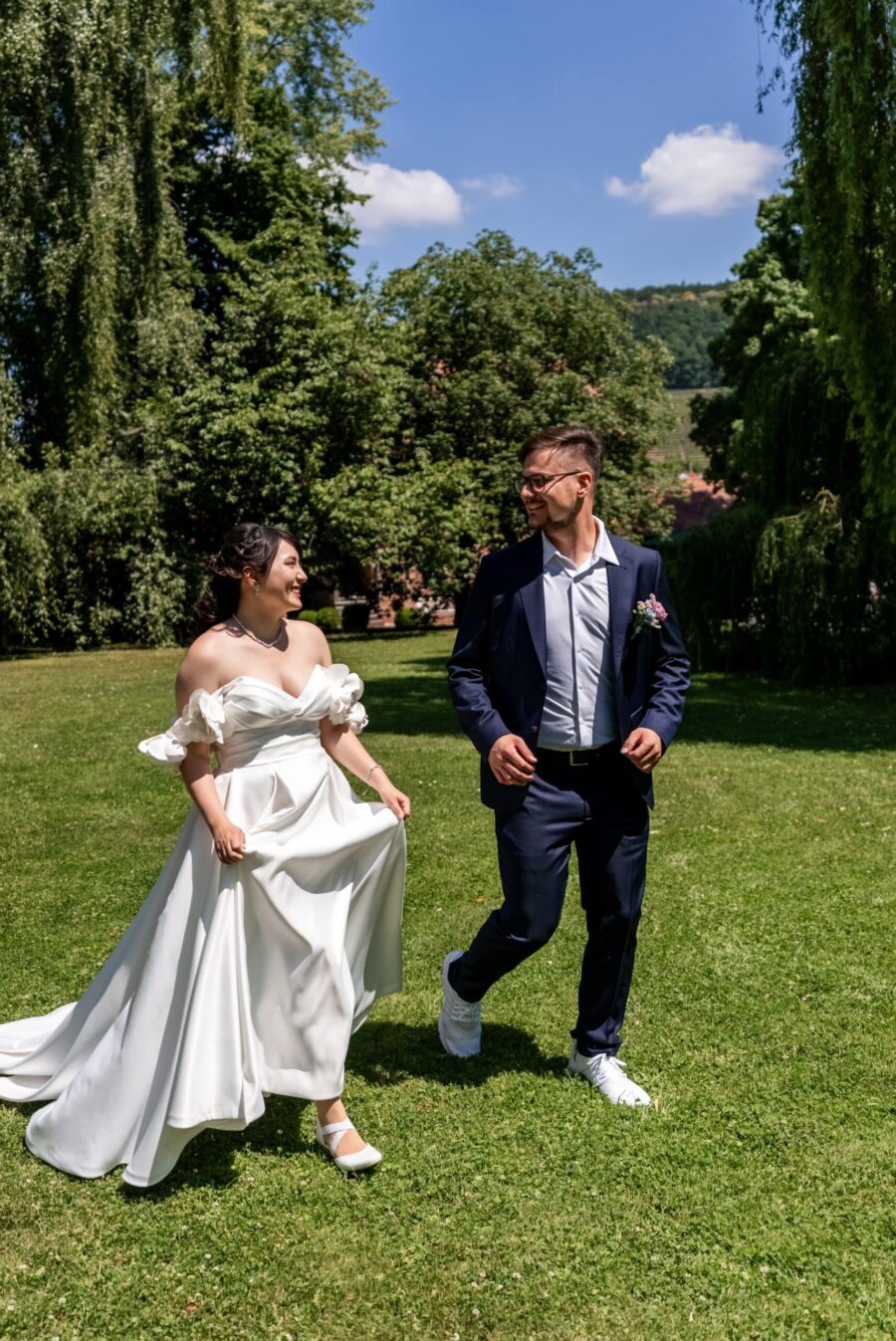 Brautpaar im Garten läuft lachend Hand in Hand Hofgut Hünersdorff