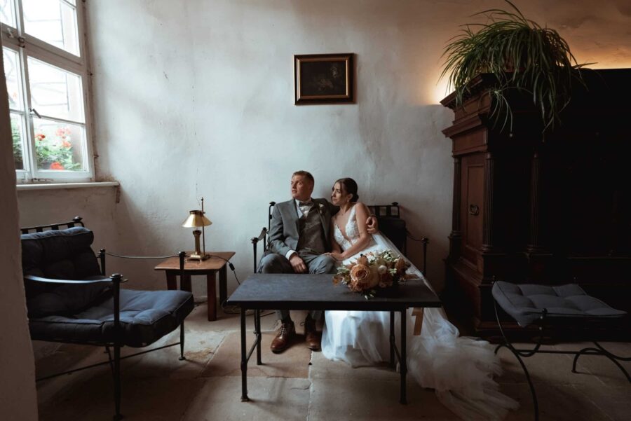 Brautpaar entspannt in gemütlicher Lounge-Ecke