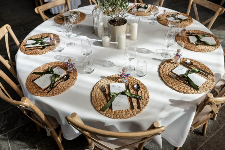 Hochzeitsgedeckter Tisch mit Menü und Kerzen.