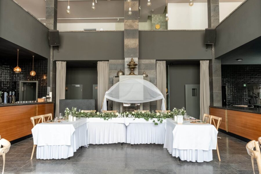 Hochzeitsdeko mit Tisch und Blumengesteck im Festsaal