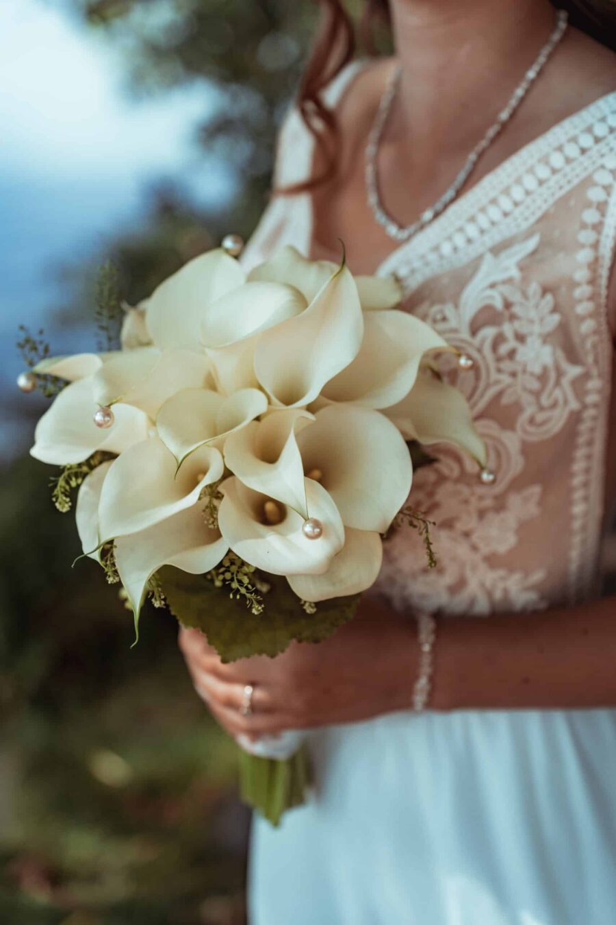 Braut hält weißen Calla-Brautstrauß