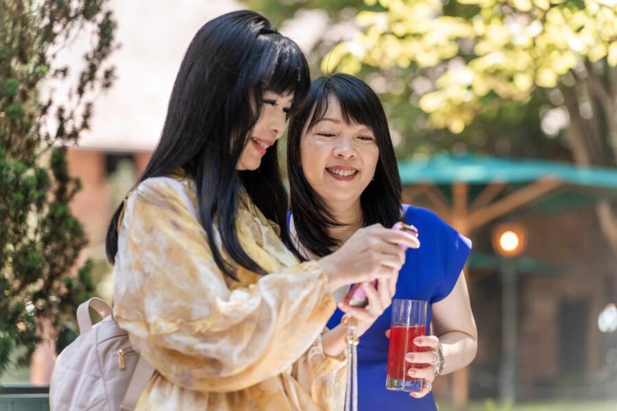 Gäste lächeln bei Sommerhochzeit im Garten. Hofgut Hünersdorff