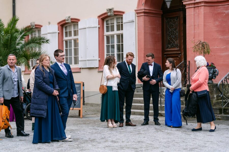 Hochzeitsgäste vor dem Trauort im Hof