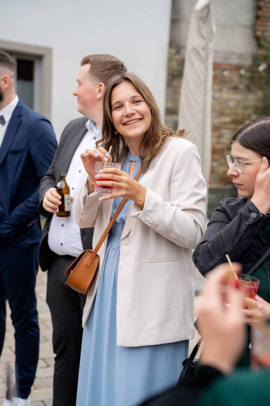 Hochzeitsgäste mit Cocktails im Freien