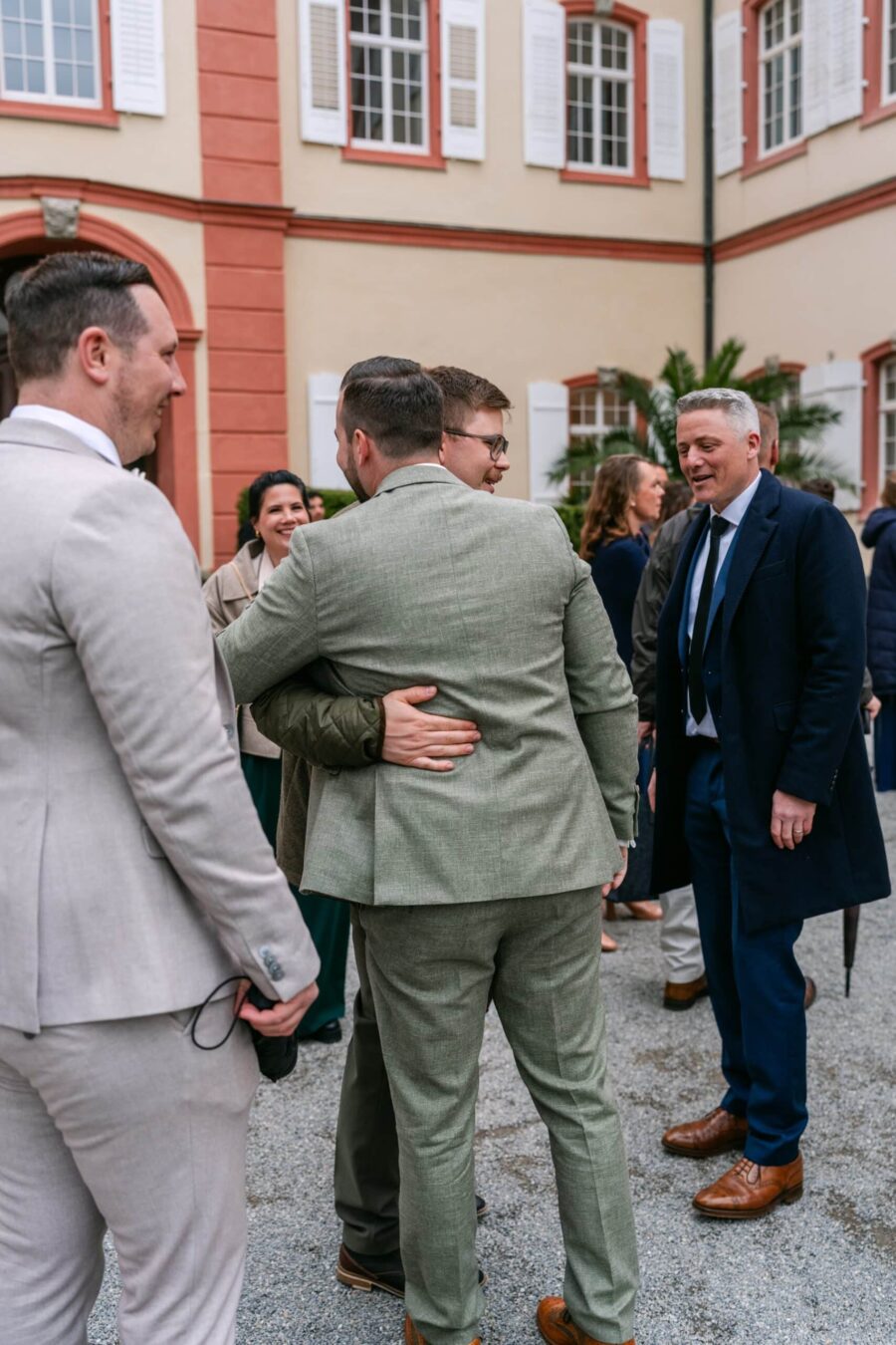 Hochzeit Insel Mainau Bodensee – Heiraten am Bodensee 183 Hochzeitsgäste umarmen sich im Innenhof
