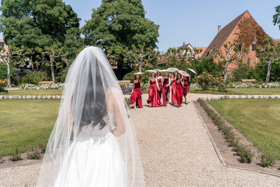 Braut schaut auf Freundinnen im Garten, Hotel Schindlerhof