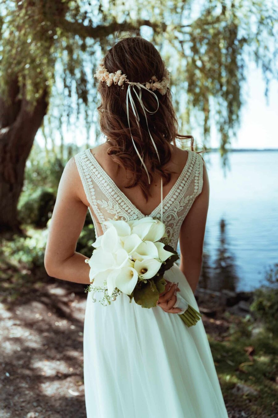 Braut mit Blumenstrauß am Seeufer