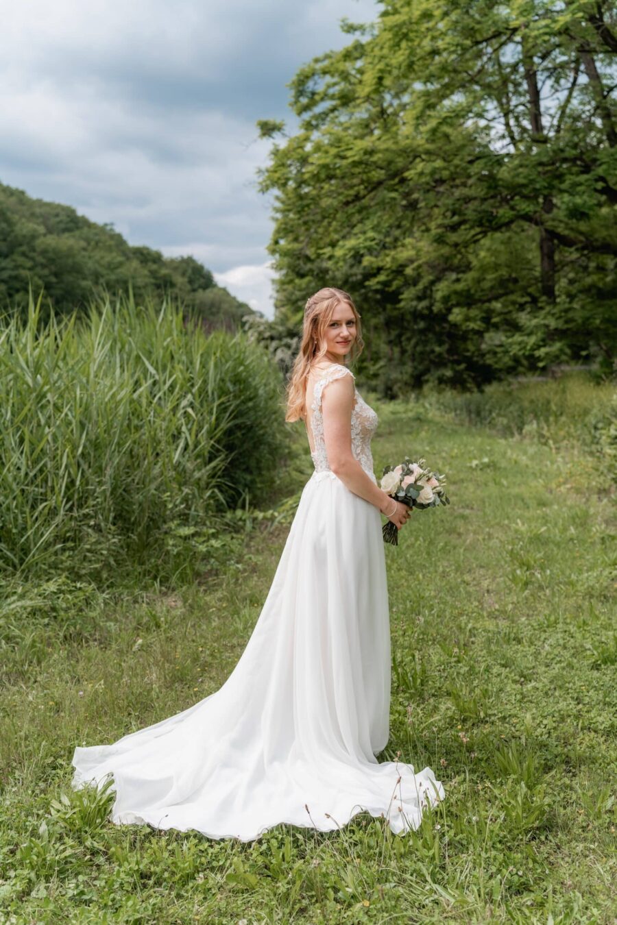 Braut im Hochzeitskleid im grünen Garten