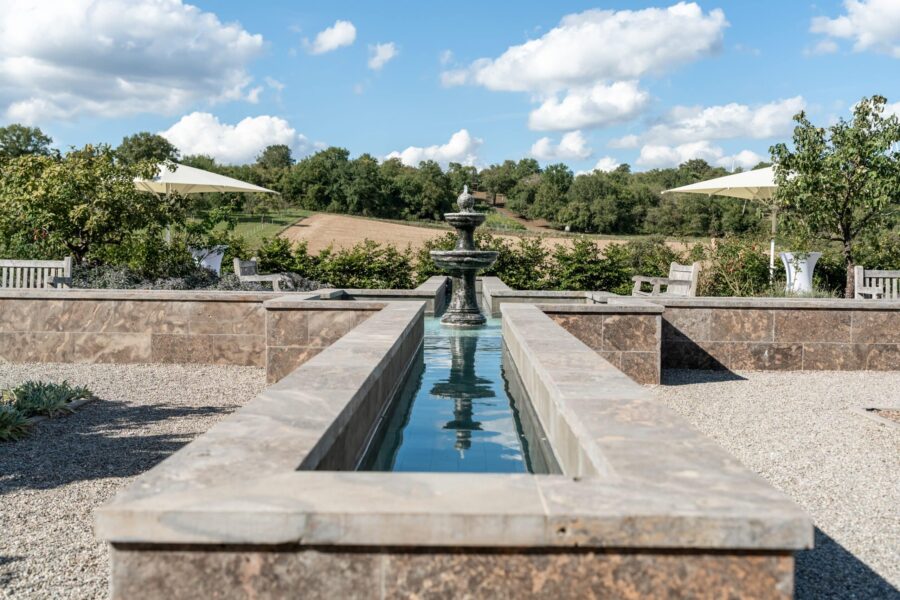 Gartenanlage mit Brunnen und Sitzbereich.