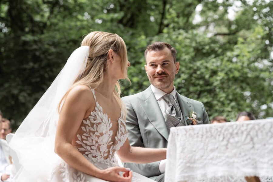 Brautpaar lächelnd beim Hochzeitsempfang im Freien