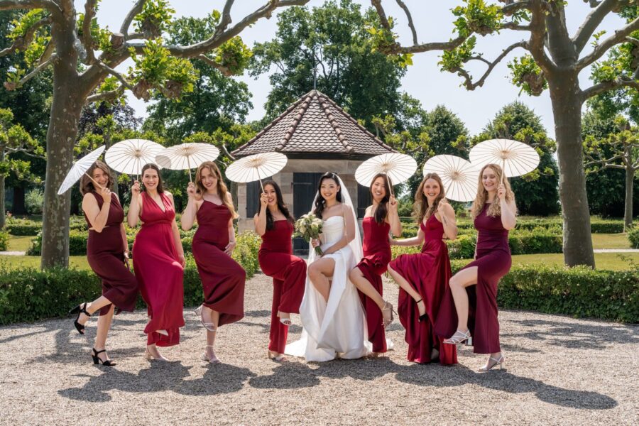 Brautjungfern posieren mit Schirmen im Garten, Hotel Schindlerhof