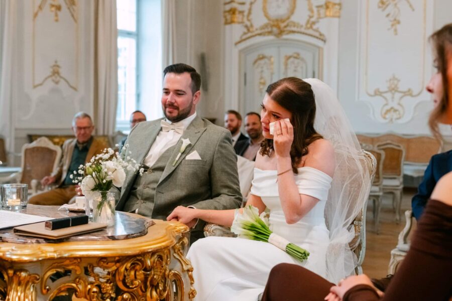 Hochzeit Insel Mainau Bodensee – Heiraten am Bodensee 79 Brautpaar bei Trauung, Braut gerührt im Prunksaal