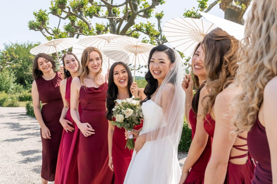 Braut und Brautjungfern mit Sonnenschirmen im Garten, Hotel Schindlerhof