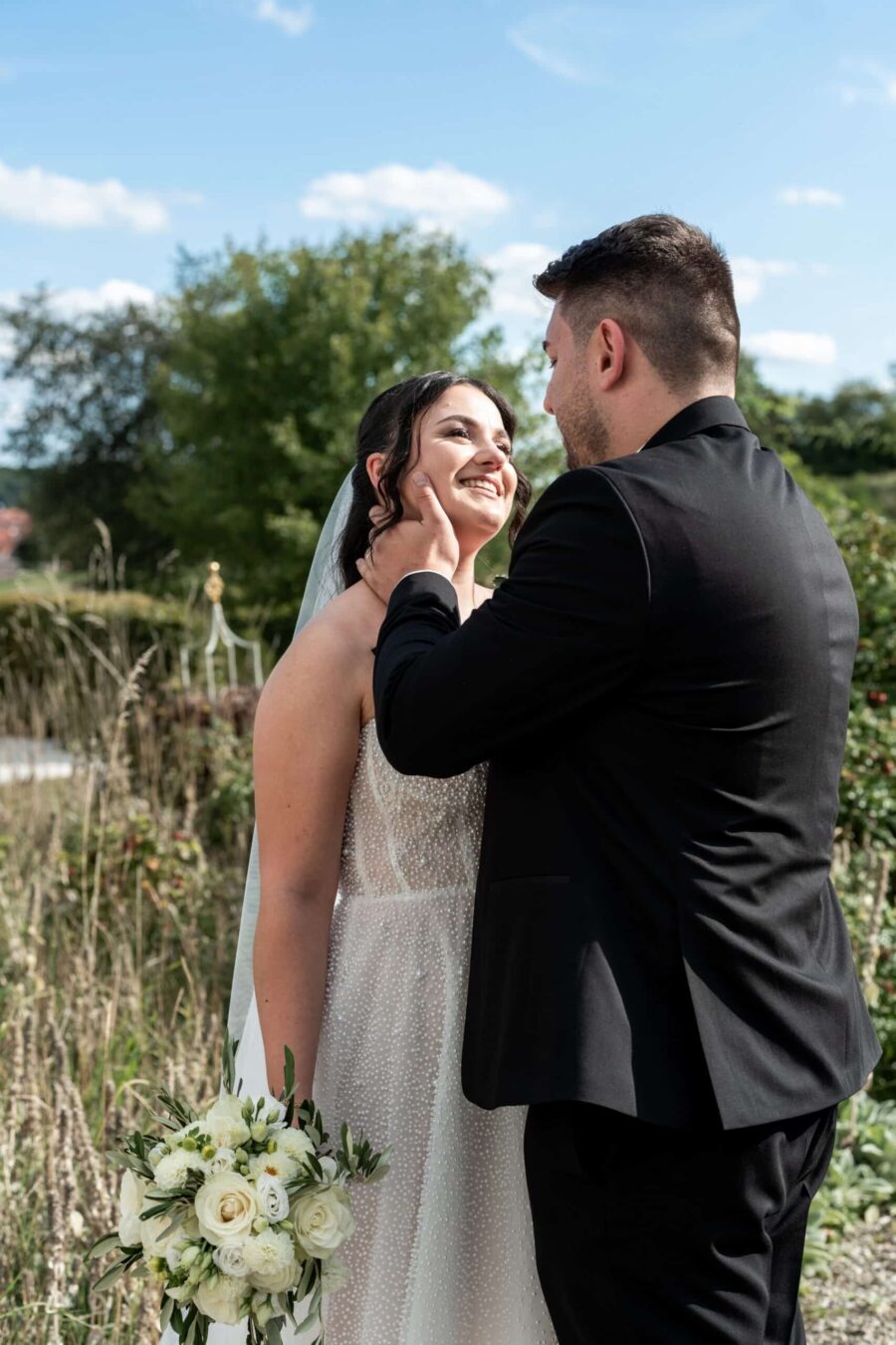 Brautpaar im Garten mit Blumenstrauß