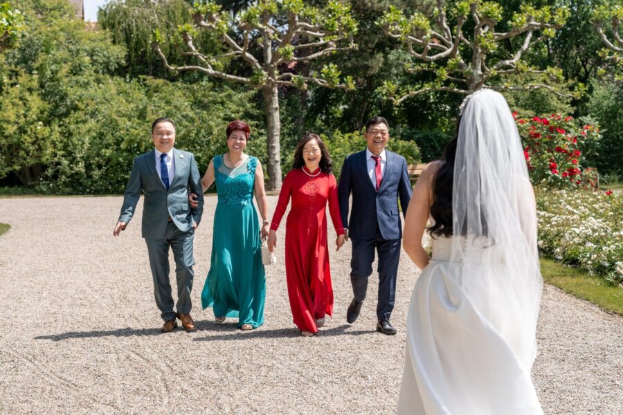 Braut geht Gästen entgegen im Garten, Hotel Schindlerhof