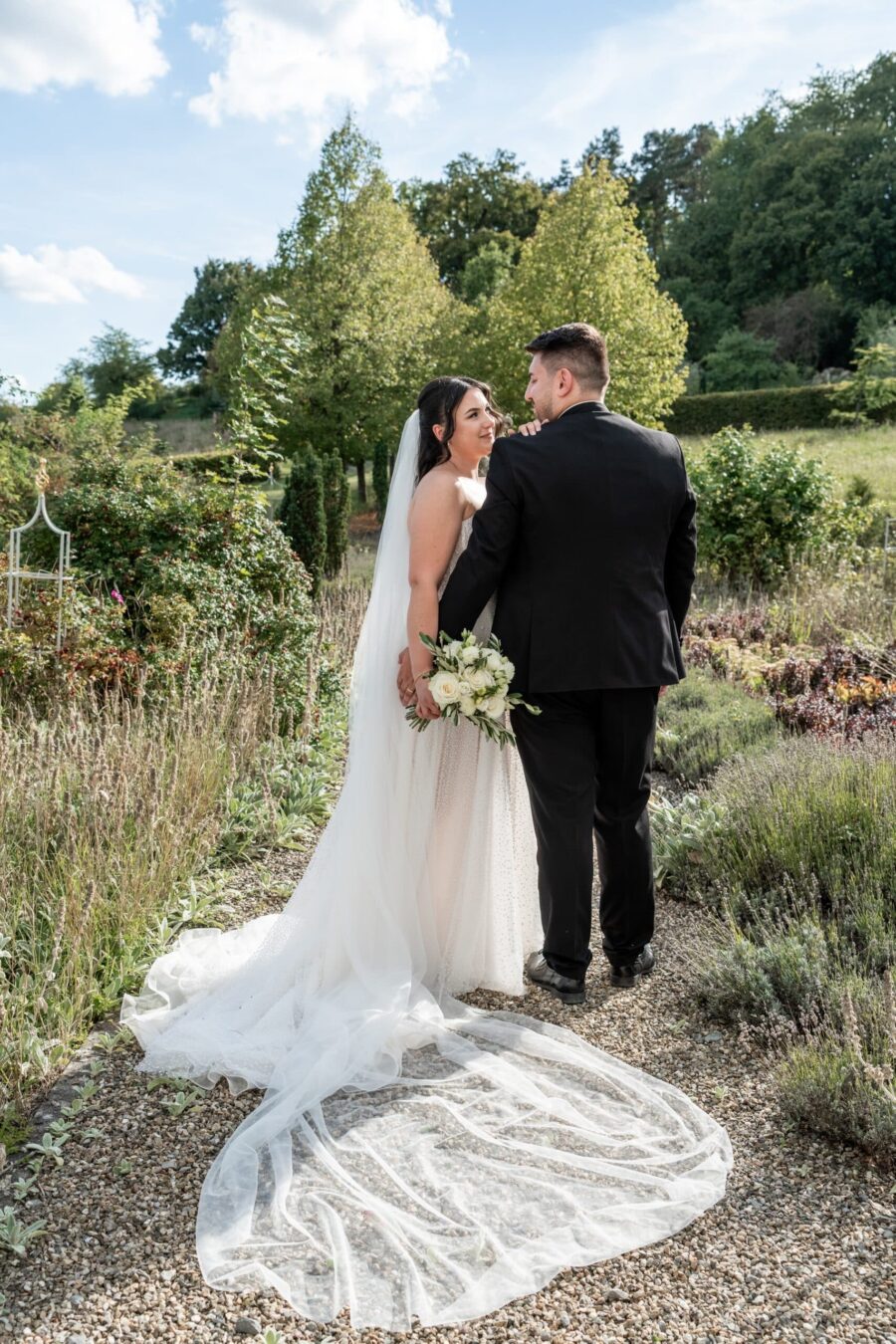 Brautpaar im Sommergarten mit Blumenstrauß