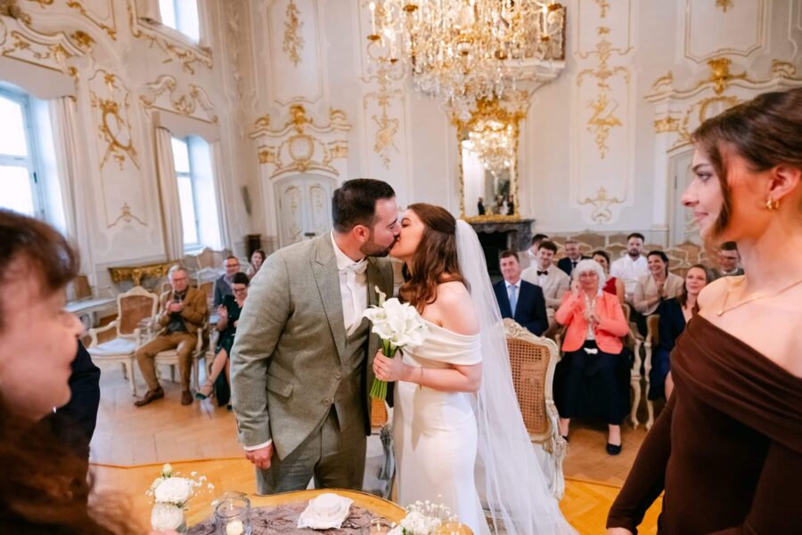 Brautpaarkuss im barocken Trausaal, Gäste applaudieren