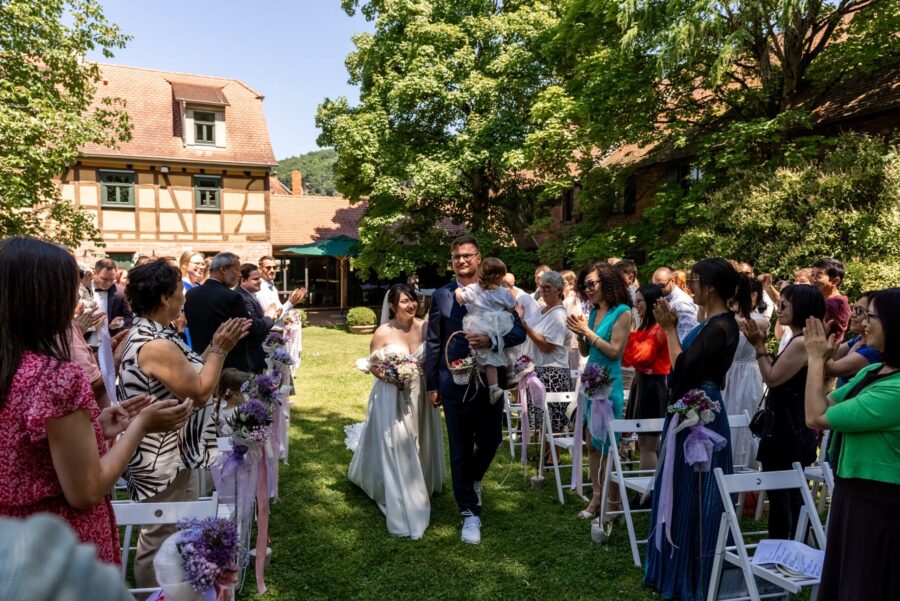 Hochzeitsauszug im Garten mit applaudierenden Gästen. Hofgut Hünersdorff