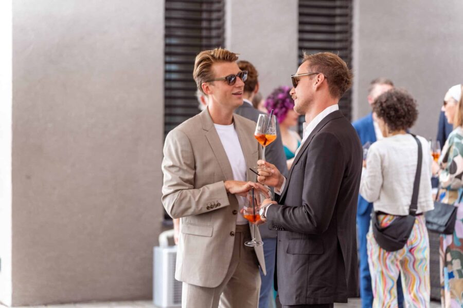 Gäste mit Getränken bei Hochzeitsempfang draußen