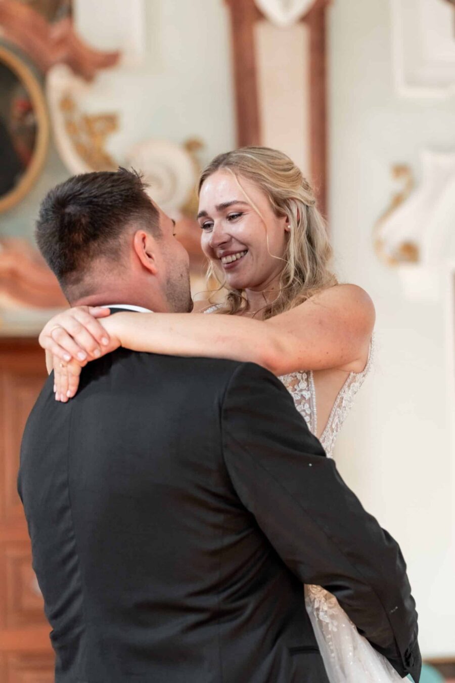 Brautpaar umarmt sich beim Hochzeitstanz in der Kirche